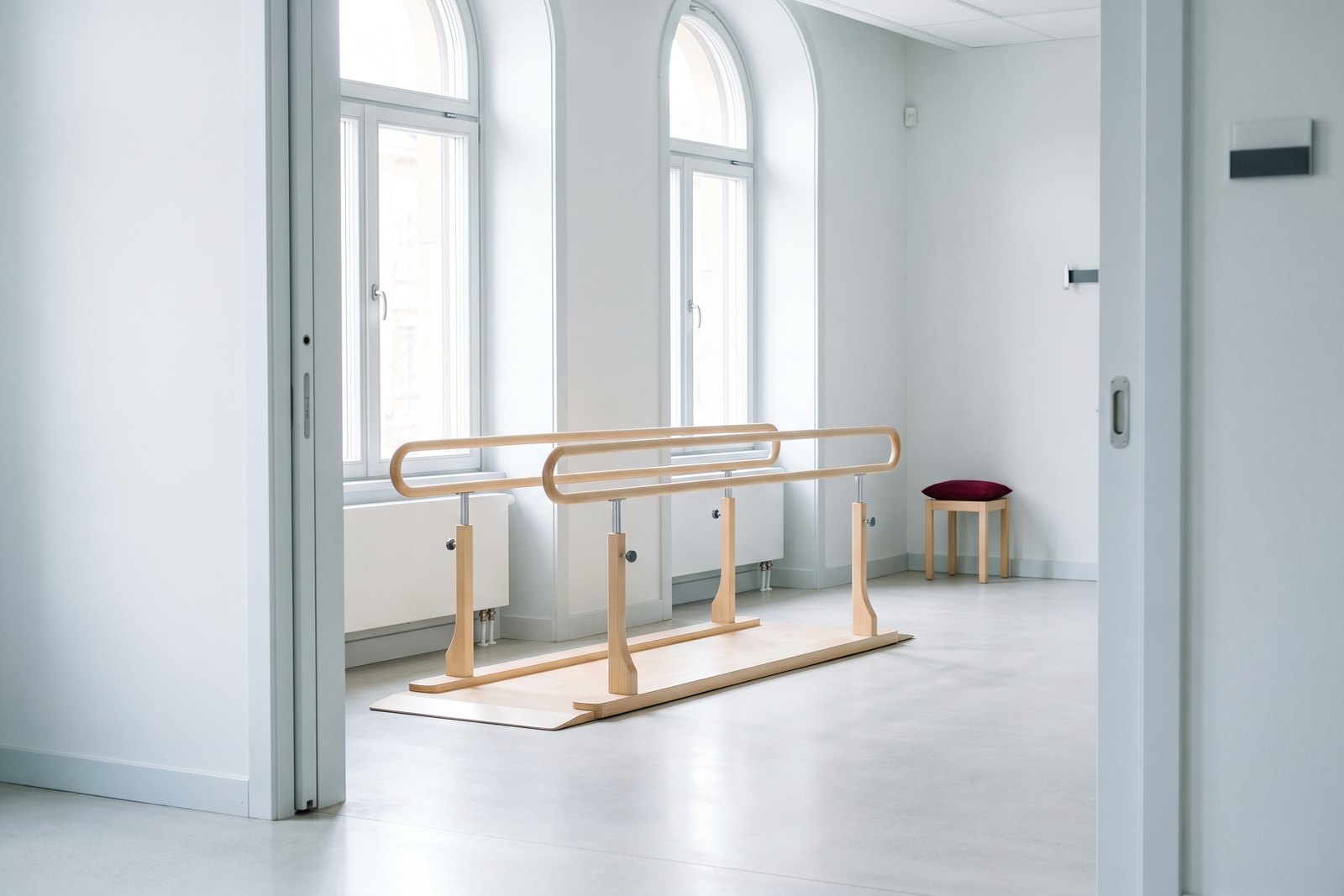 Empty wooden parallel bars in a bright rehabilitation hall