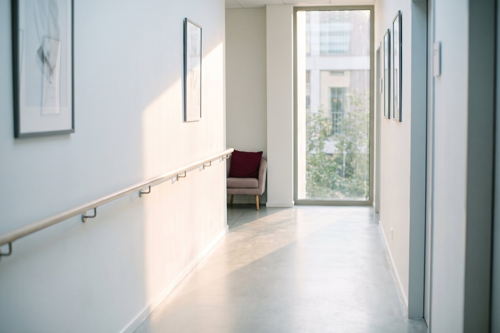 A handrail along the wall of a light clinic corridor