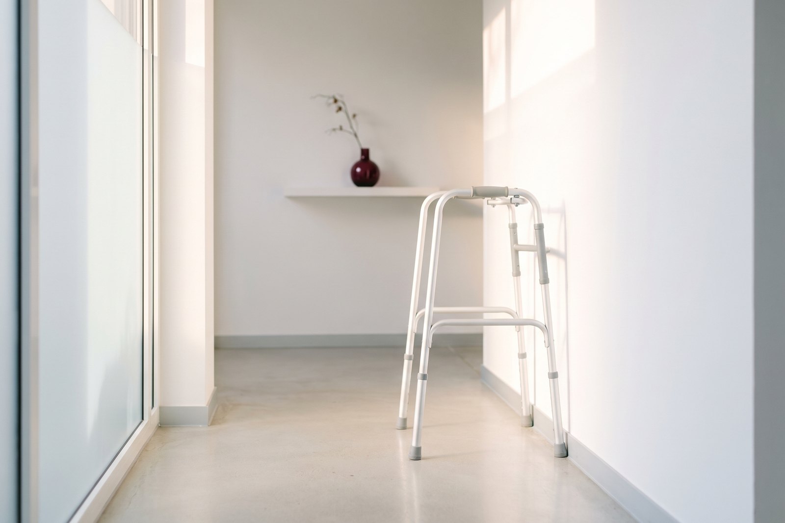 A walking frame against the wall of a light clinic corridor