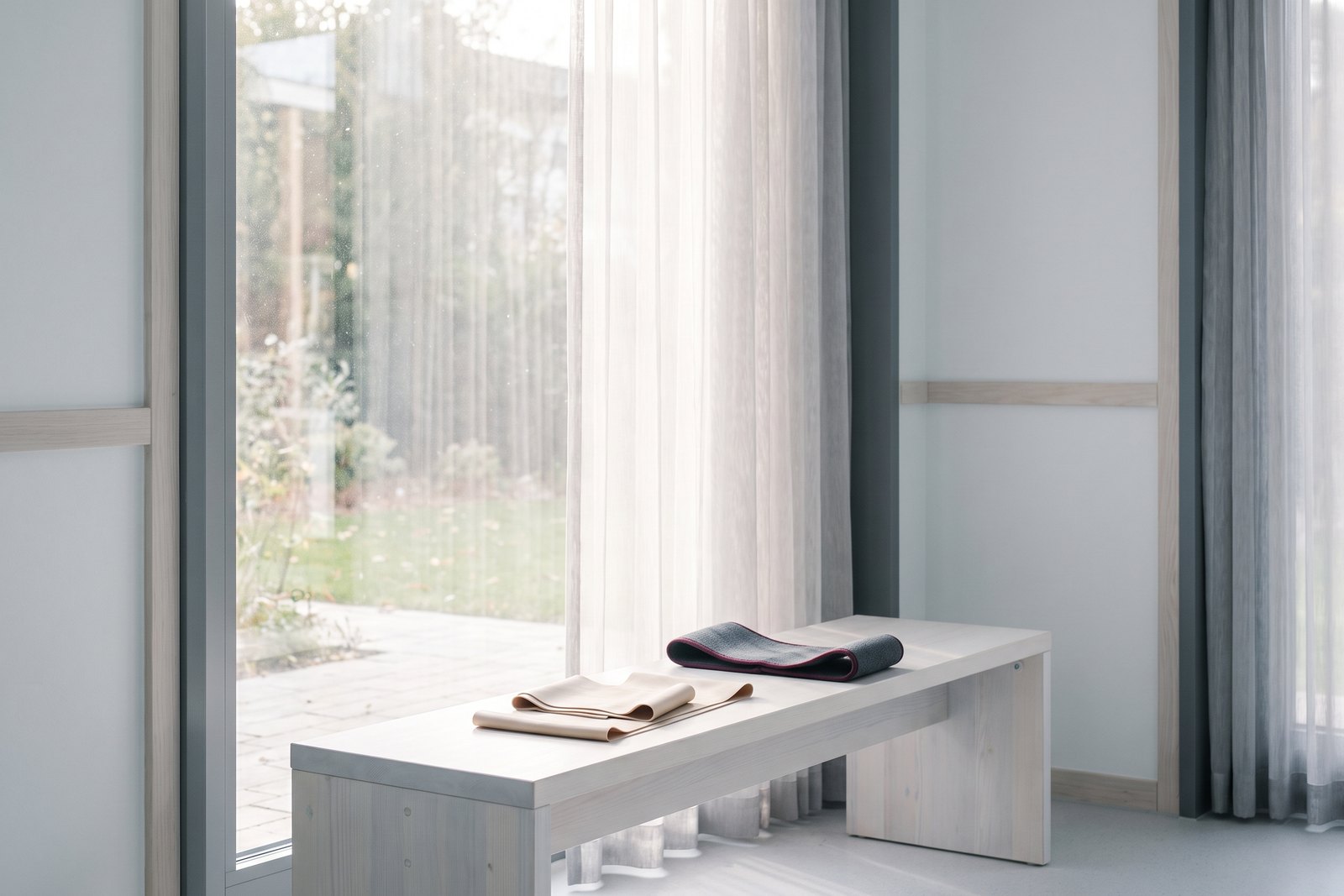 A resistance band and a padded support strap on a wooden bench